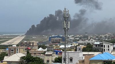 Smoke billows from a plane that flipped over after a crash landing in Mogadishu in this picture obtained from social media. Photo: Abdirahman Mohamed Arab via Reuters