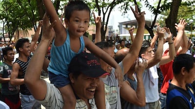 People celebrate as Philippine boxing icon Manny Pacquiao downs Timothy Bradley Jr. of the US in the 10th round in Las Vegas, Nevada, during a live telecast of their welterweight title fight at a public park in suburban Manila on April 10, 2016. AFP / TED ALJIBE
