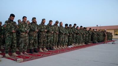 Afghan National Army soldiers pray after breaking the fast during the holy month of Ramadan at their base in Herat, western Afghanistan. EPA