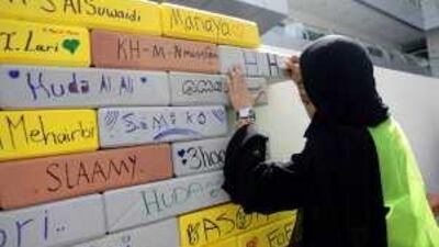 A student from Zayed University helps to build a wall of styrofoam bricks as part of a project to raise funds for a special needs-school in Abu Dhabi.