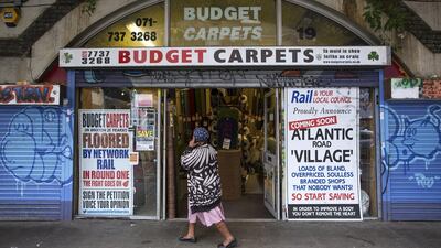 A woman walks past a shop under Brixton Arches. Landlord Network Rail's plan to regenerate the area is likely to take a year. Dan Kitwood / Getty