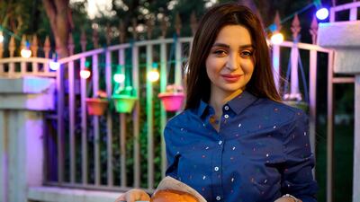 Zilan Serwud, the 22-year-old owner of the Zee Burger food truck, poses for a picture with a burger in Arbil, the capital of the northern Iraqi Kurdish autonomous region. AFP