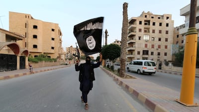 An ISIS member waves the extremist group's flag in Raqqa, Syria 2014. Reuters
