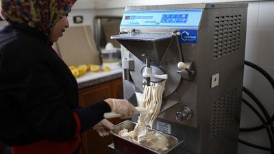 Noora Abu Jomiza, a 32-year-old gelato maker, takes the latest banana-flavoured batch out of the machine in Gelato di Gaza’s production room in the Bureij refugee camp. Rosie Scammell for The National