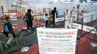 Passengers walk past a notice displayed near a quarantine control station at Narita airport in Narita, Japan. EPA