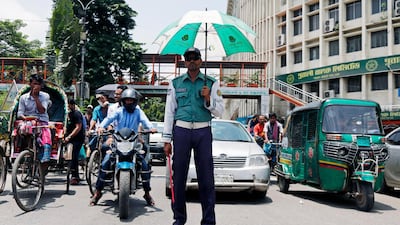 A Bangladeshi traffic policeman on duty has an umbrella in his hand against the sunshine as he directs traffic in the Shahbag area of Dhaka, Bangladesh. EPA / MONIRUL ALAM