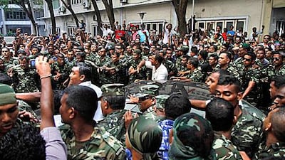 Maldives President Mohamed Nasheed's car is escorted to the President's Office by the military to give his resignation speech in Male today.