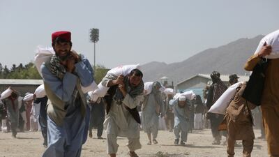 Afghans carry sacks of rice donated by China at a distribution centre in Kabul, Afghanistan, in April 2022. Reuters
