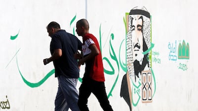 People jog in a public park past wall art showing Saudi's King Salman in Jeddah. AP Photo