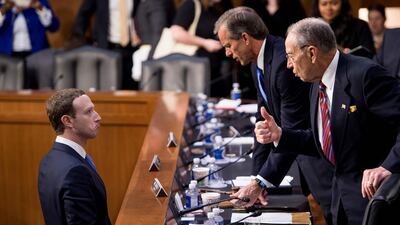 Facebook CEO Mark Zuckerberg speaks with Senator John Thune and Senator Chuck Grassley following a joint hearing of the Senate Commerce, Science and Transportation Committee and Senate Judiciary Committee. Brendan Smialowski / AFP