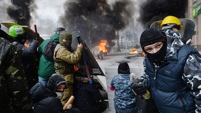 A demonstrator holds an incendiary device as protesters clash with police. Sergei Supinsky / AFP