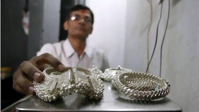 A silver trader weighs ornaments in Ahmedabad, India. Soaring silver prices are driving Indians to recycle jewellery into bars as an easier, more reliable way to invest.