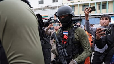 An armed police officer enters Debsirin Nonthaburi School. Reuters