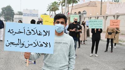 A business owner in Kuwait City with a placard reading 'Closure ends in bankruptcy and jail'. The Kuwaiti government is being urged to rethink its closure of salons and health clubs to contain the spread of the coronavirus. EPA