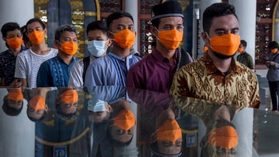 Indonesian Muslims wear masks as they queue to attend Friday Prayers amid the coronavirus pandemic, at a mosque in Surabaya, East Java, Indonesia. EPA
