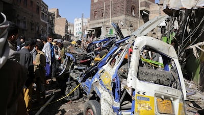People gather around the wreckage of a mini van at the site of a US strike in Sanaa on April 21. Reuters