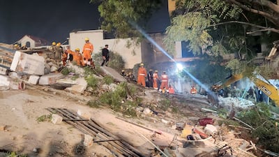 Rescue workers on the debris of the collapsed building in Lucknow on Tuesday. Reuters