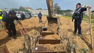 Volunteers bury people killed in overnight Israeli strikes at a temporary graveyard in the coastal Lebanese city of Tyre on Sunday. AFP