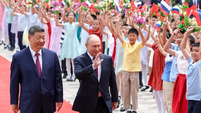 Dozens of children holding Russian and Chinese flags greeted the leaders. AFP