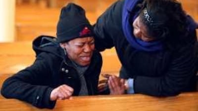 A women is comforted as she prays at St Jerome's Church in the Flatbush area of Brooklyn, New York.