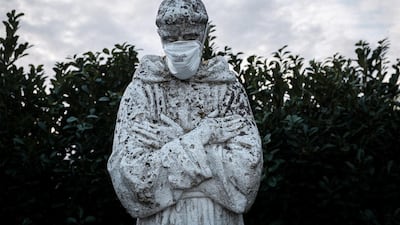 A protective mask has been put on the face of a statue of Italy's patron saint, St. Francis, in San Fiorano, one of the towns on lockdown due to a coronavirus outbreak, in this picture taken by schoolteacher Marzio Toniolo in San Fiorano, Italy. Reuters