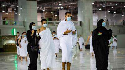 Muslims pray around the Kaaba, the cubic building at the Grand Mosque, during the first day of Umrah in the Muslim holy city of Makkah, Saudi Arabia. A very small, limited number of people donning the white terrycloth garment symbolic of the Muslim pilgrimage circled Islam's holiest site in Mecca on Sunday after Saudi Arabia lifted coronavirus restrictions that had been in place for months. Saudi Ministry of Hajj and Umrah via AP