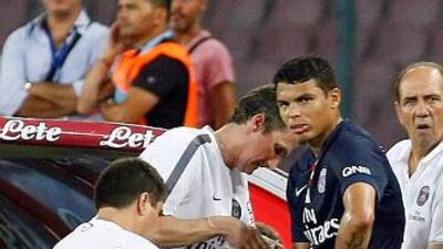 Paris Saint-Germain defender Thiago Silva, right, receives medical care after being injured during the friendly football match between SSC Napoli and Paris Saint-Germain FC as part of the 2014 Acqua Lete Cup, on August 11, 2014 at the San Paolo Stadium, in Naples. AFP PHOTO / CARLO HERMANN