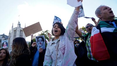 People chant slogans and hold up images of Mahsa Amini during a protest in London in solidarity with those in Iran. AFP