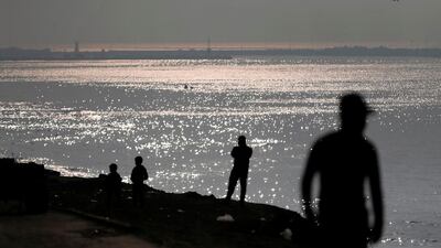Palestinians stand by the Mediterranean Sea during sunset at the al-Shati refugee camp in Gaza City. AFP