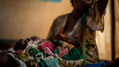 Abeba Gebru, 37, from the village of Getskimilesley, sits with her malnourished daughter, Tigsti Mahderekal, 20 days old, in the treatment tent of a medical clinic in the town of Abi Adi, in the Tigray region of northern Ethiopia. AP Photo