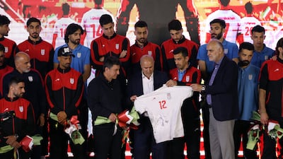 Iranian football federation head Mehdi Taj holds an Iran shirt during a farewell ceremony in Tehran on May 13. EPA