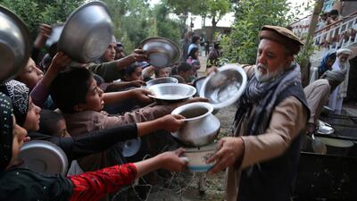 An Afghan man distributes food during the first day of the Islamic holy month of Ramadan in Ghazni province. Zakeria Hashimi / AFP