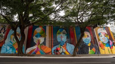 A cyclist rides past a mural created by Brazilian street artist Eduardo Kobra that features children wearing masks with religious symbols from Islam, Buddhism, Christianity, Judaism and Hinduism, amid the Covid-19 pandemic in Sao Paulo, Brazil. AP Photo