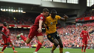 Liverpool's James Milner battles with Wolverhampton Wanderers's Tote Gomes in a Premier League game at Anfield. AFP