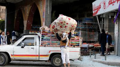 A worker collects belongings from his store which was smashed up during clashes between Saleh's forces and Houthis,in Sanaa. Khaled Abdullah / Reuters