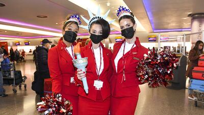 Virgin Atlantic cabin crew members pose at London Heathrow Airport’s Terminal 3 before the departure of Virgin Atlantic flight VS3