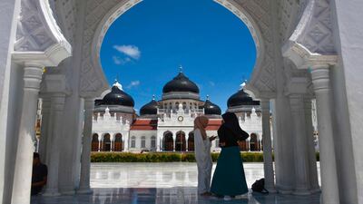 Muslim women stand outside Baiturrahman grand mosque in Banda Aceh. AFP