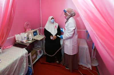 A Palestinian doctor prepares a woman for a breast cancer check up inside a mobile clinic set up in a truck. Reuters
