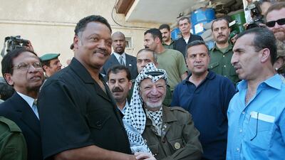 Palestinian leader Yasser Arafat (R) meets US civil rights leader Jesse Jackson, surrounded by Arafat's aides and bodyguards and members of Jackson's delegation after their meeting on July 29, 2002 in Arafat's besieged headquarters in the West Bank city of Ramallah. Getty Images