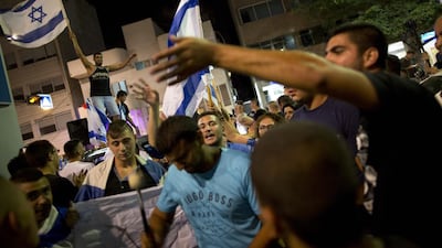An Israeli right wing activist waves the Israeli flag in support of Israel's offensive in Gaza, during a demonstration, in Tel Aviv, Israel on July 19, 2014. Oded Balilty/AP Photo