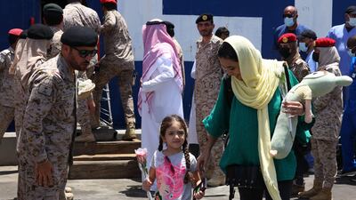 Saudi soldiers welcome people from Sudan as they arrive at the King Faisal Naval Base in Jeddah. AFP