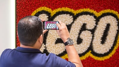 Visitors taking photos of the Lego logo at the reception of the new Lego office. Leslie Pableo for The National
