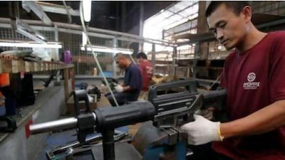 A formerly illegal gunsmith inspects a newly assembled multi-action shotgun at Shooters Arms, a gun manufacturing company in Cebu in the central Philippines.