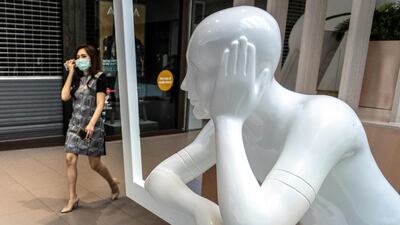 A woman enters a shopping mall partially closed to combat the spread of coronavirus, in Bangkok. AFP