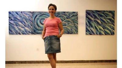 Boryana Korcheva in front of her works on display at the Fujairah Tennis Club. The exhibition, Whoosh!, was named after her triptych of fish caught in a whirl of motion and colour.