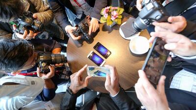 Attendees take photographs of the Mi5 smartphone, manufactured by Xiaomi, during its launch at the Mobile World Congress in Barcelona. Chris Ratcliffe / Bloomberg