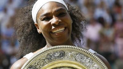 Serena Williams holds the trophy after winning the women's singles final against Garbine Muguruza at the All England Club in Wimbledon, London, Saturday July 11, 2015. (AP Photo/Kirsty Wigglesworth)