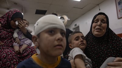Children and women wait to receive treatment at Al Najjar Hospital following an Israeli air strike that hit their home in Rafah. EPA