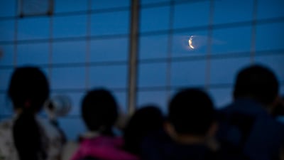 People watch the eclipse from the Central Radio and TV Tower in Beijing, China. It was the first total lunar eclipse in more than two years. AP