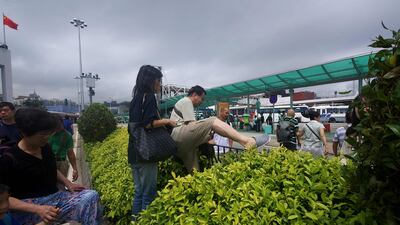 Commuters climb over bushes and railings in the middle of a main road after underground passageways were blocked by floodwaters brought on by Typhoon Hato in Macau. Anthony Wallace / AFP
